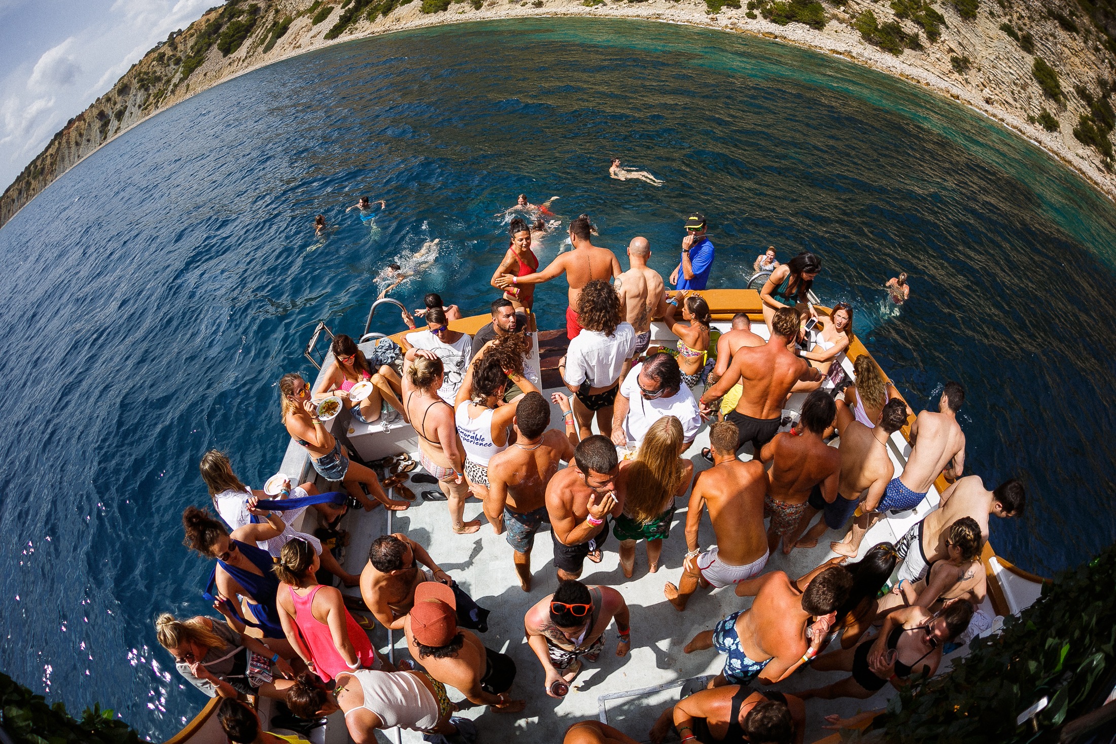 Fiesta en barco con gente nadando · Blanes