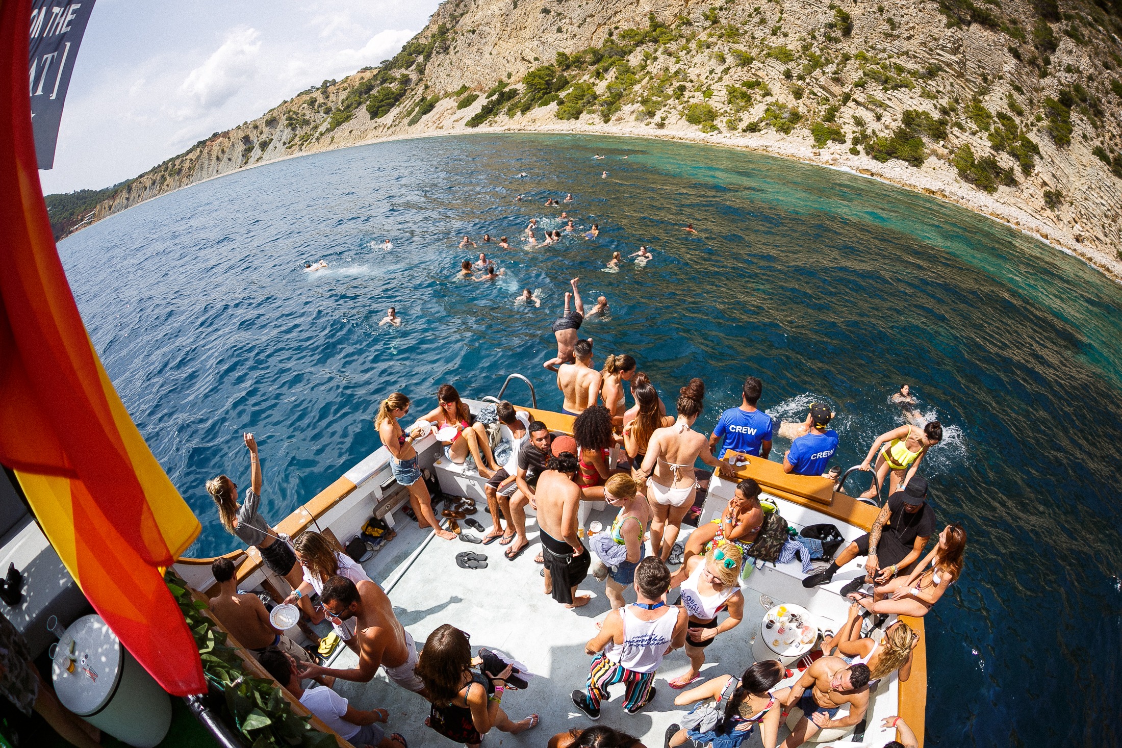 Barco con bandera española · Gente nadando Blanes